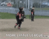 a little girl is playing baseball on a field with the words `` more little league '' above her .