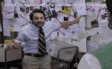 a man in a blue shirt and tie is standing in front of a wall with papers on it ..