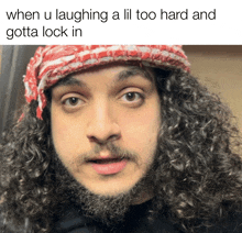 a man with curly hair and a beard is wearing a red and white scarf on his head