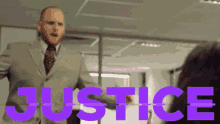 a man in a suit and tie stands in front of a sign that says justice