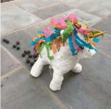 a stuffed unicorn with colorful ribbons on it 's mane