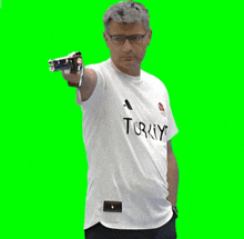 a man wearing a turkey shirt is pointing a gun at the camera