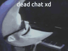 a man wearing a mask is playing a piano and the words dead chat xd are visible