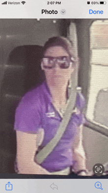 a woman wearing sunglasses and a purple shirt is on a phone screen