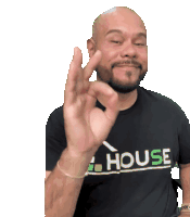 a man wearing a black shirt that says house giving an ok sign