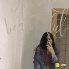 a woman is taking a picture of herself in front of a mirror with the words beautiful written on it