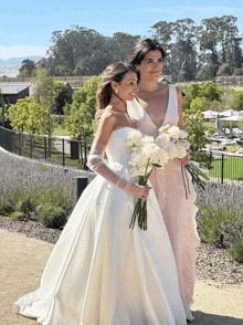 a bride and a bridesmaid are posing for a picture