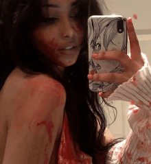 a woman with blood on her face is taking a picture of herself with her phone