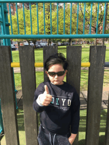 a young boy wearing sunglasses and a shirt that says okyd