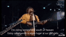 a man is playing a guitar and singing into a microphone with the words bon jovi srahan heading back to santa fe