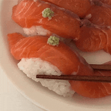 a plate of sushi with chopsticks on it