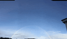 a rainbow is visible in the sky above a building