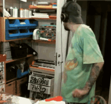 a man wearing headphones is standing in front of a shelf with a drawer labeled ' shadow ' on it