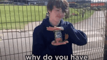 a young man is holding a can of heinz ketchup in his hands .