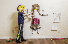 a boy and a girl are playing with a cardboard box that says bad stuff