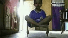 a young boy is sitting on the floor with his legs crossed in a living room .