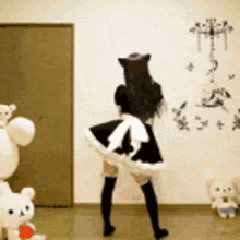 a woman in a maid costume is dancing in front of stuffed animals