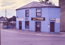 a blue building with a black sign that says bicycles & sports