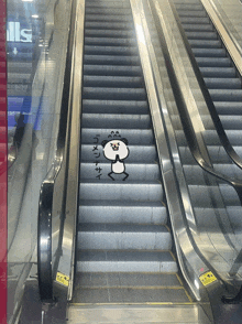 an escalator with a drawing of a panda on the bottom steps