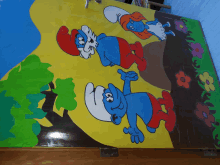 a painting of three smurfs on a wooden table