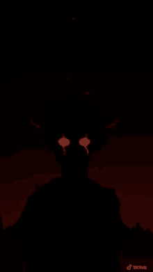 a silhouette of a monster with red eyes is standing in the dark .