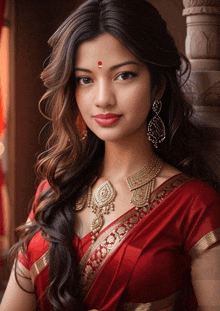 a woman wearing a red saree and gold jewelry with a red dot on her forehead