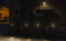 a group of people riding scooters in the dark