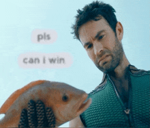 a man is holding a fish in front of a screen that says " pls can i win "