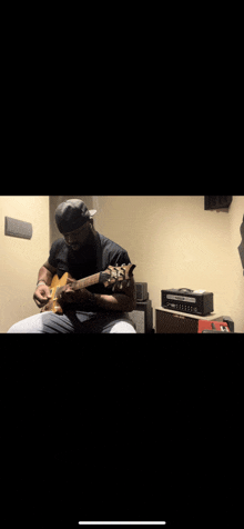 a man is playing a guitar in a dark room .