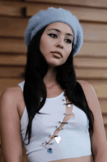 a woman wearing a blue fur hat and a white tank top