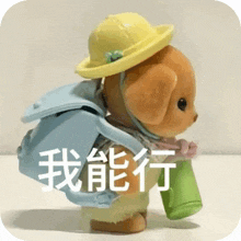 a stuffed animal wearing a yellow hat and carrying a backpack