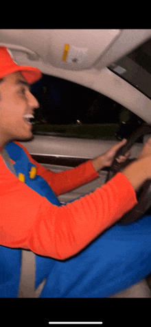 a man wearing a mario costume is driving a car