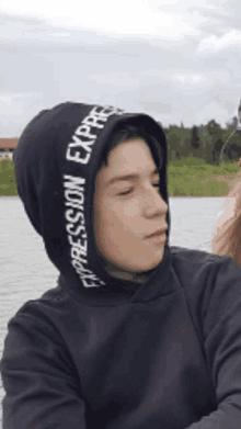 a boy wearing a black hoodie that says expression express on it