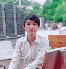 a young man wearing a white shirt with the word hugo on the collar