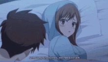 a man and a woman are laying on a bed and the woman is wearing a blue hoodie .