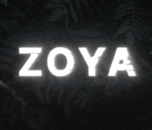 the word zoya is glowing in the dark with leaves in the background