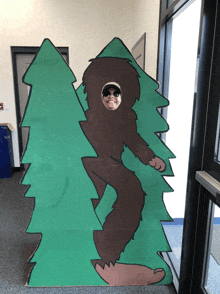 a cardboard cutout of a bigfoot with a person 's face in the hole