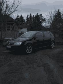 a black volkswagen with a license plate that says eh 727 tk is parked in a dirt field