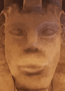 a close up of a statue 's face with a crown on it