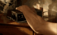 a close up of a person 's hand pressing a button on an alarm clock that shows the time as 3:00