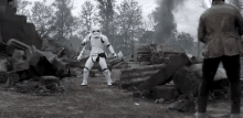 a black and white photo of a storm trooper dancing in front of a man in a brown jacket .