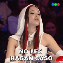 a woman with red hair is wearing a white hooded top with the words no les hagan caso written on it