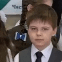 a young boy wearing a suit and tie with a blue bow tie .