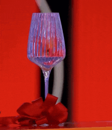 a wine glass with a red ribbon on it