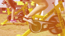 a person riding a yellow exercise bike that says run the party