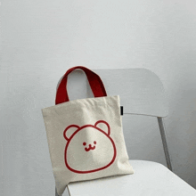 a white tote bag with a red teddy bear on it