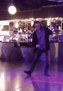 a man dancing on a dance floor with purple lights