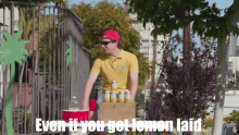 a man in a yellow shirt holding a box of lemonade says even if you get lemon laid