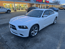 a white car is parked in front of a piggy wiggly store