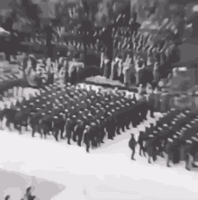 a black and white photo of a military parade in the snow .